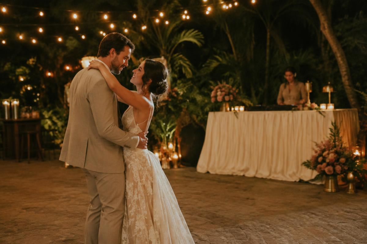 Pareja bailando bajo luces cálidas en una recepción al aire libre